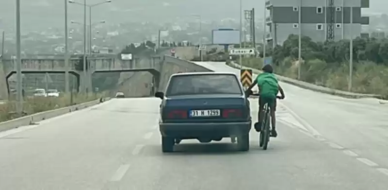 Hatay'da Otomobile Tutunarak Giden Bisikletlinin Tehlikeli Yolculuğu Kamerada 